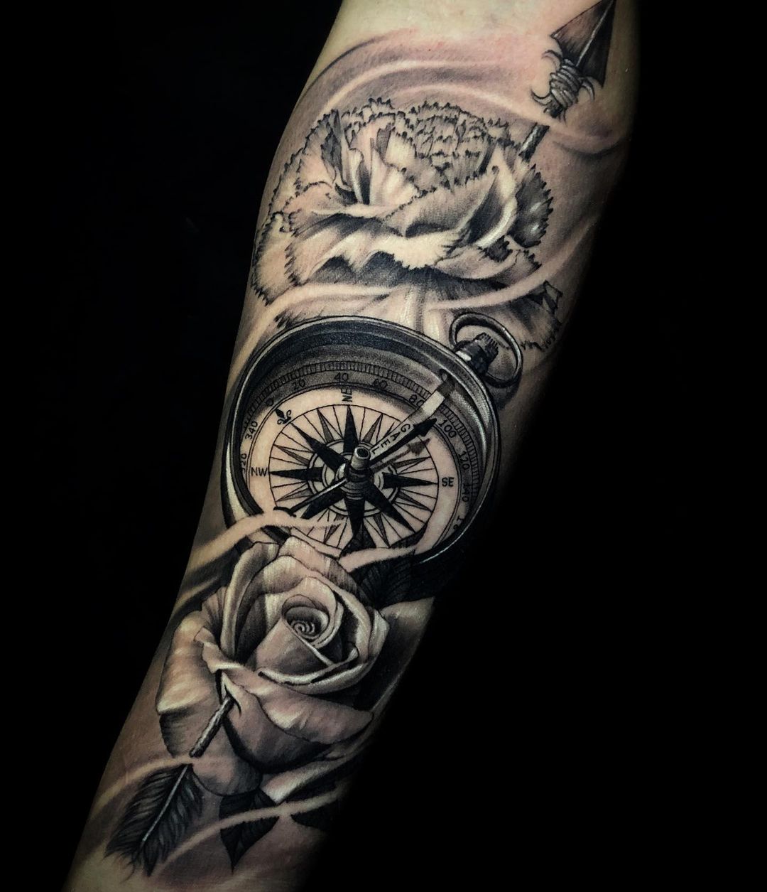 World map compass tattoo on the right inner forearm.