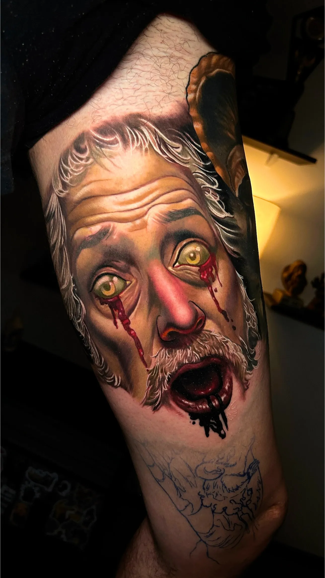 Color realism tattoo of an expressive male face with surreal bleeding eyes and dramatic shading by Inknation Studio NYC