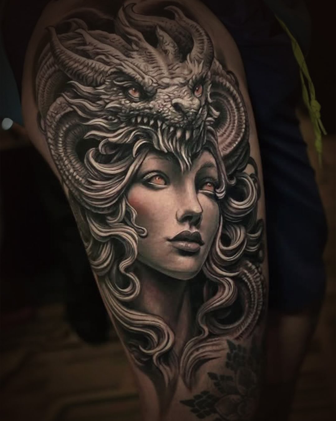 Black and grey realism tattoo of a female portrait with dragon headdress by Inknation Studio NYC
