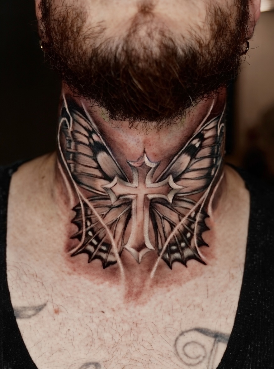 Black and grey realism cross tattoo with butterfly wings on neck, symbolism of transformation and faith, Inknation Studio NYC