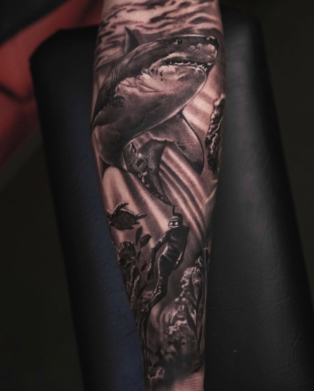 Black and grey realism great white shark tattoo on forearm with ocean waves, Inknation Studio