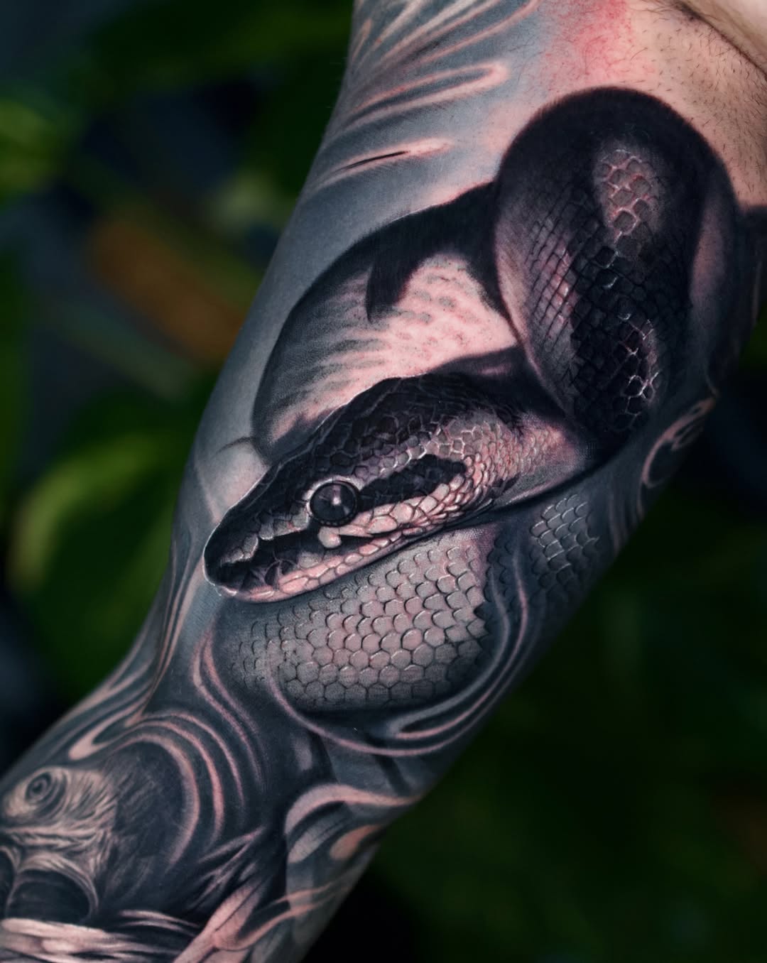 Black and grey realism python snake full arm tattoo with detailed scales and foliage, Inknation Studio NYC