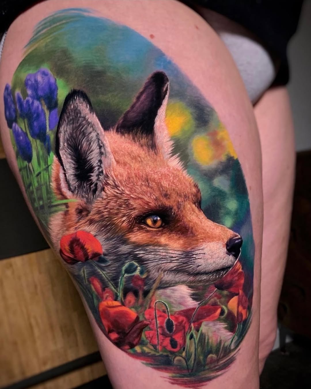 Color realism red fox thigh tattoo with golden eyes and flowers, cunning symbolism, Inknation Studio NYC