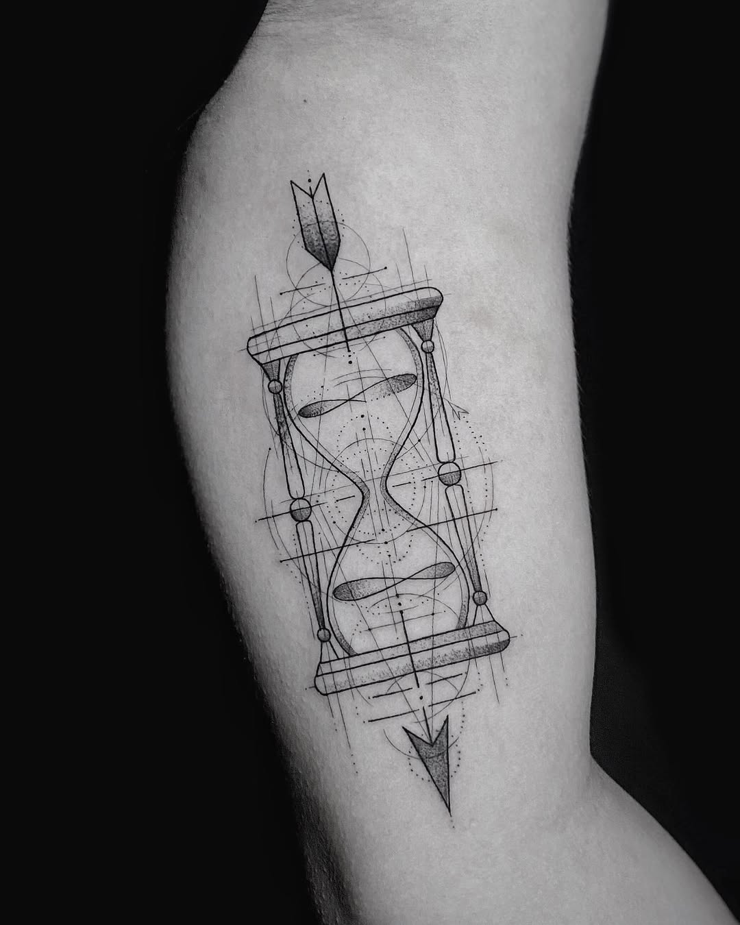 Fine line geometric hourglass tattoo with arrow and sacred geometry on arm, memento mori symbolism, Inknation Studio