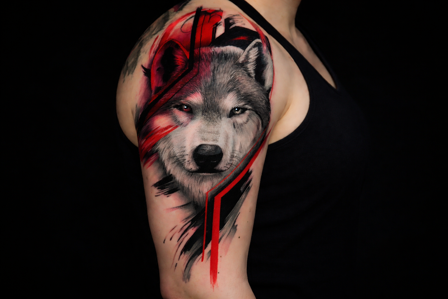 Trash polka wolf tattoo on shoulder featuring realistic wolf portrait with bold red and black graphic elements at Inknation Studio NYC